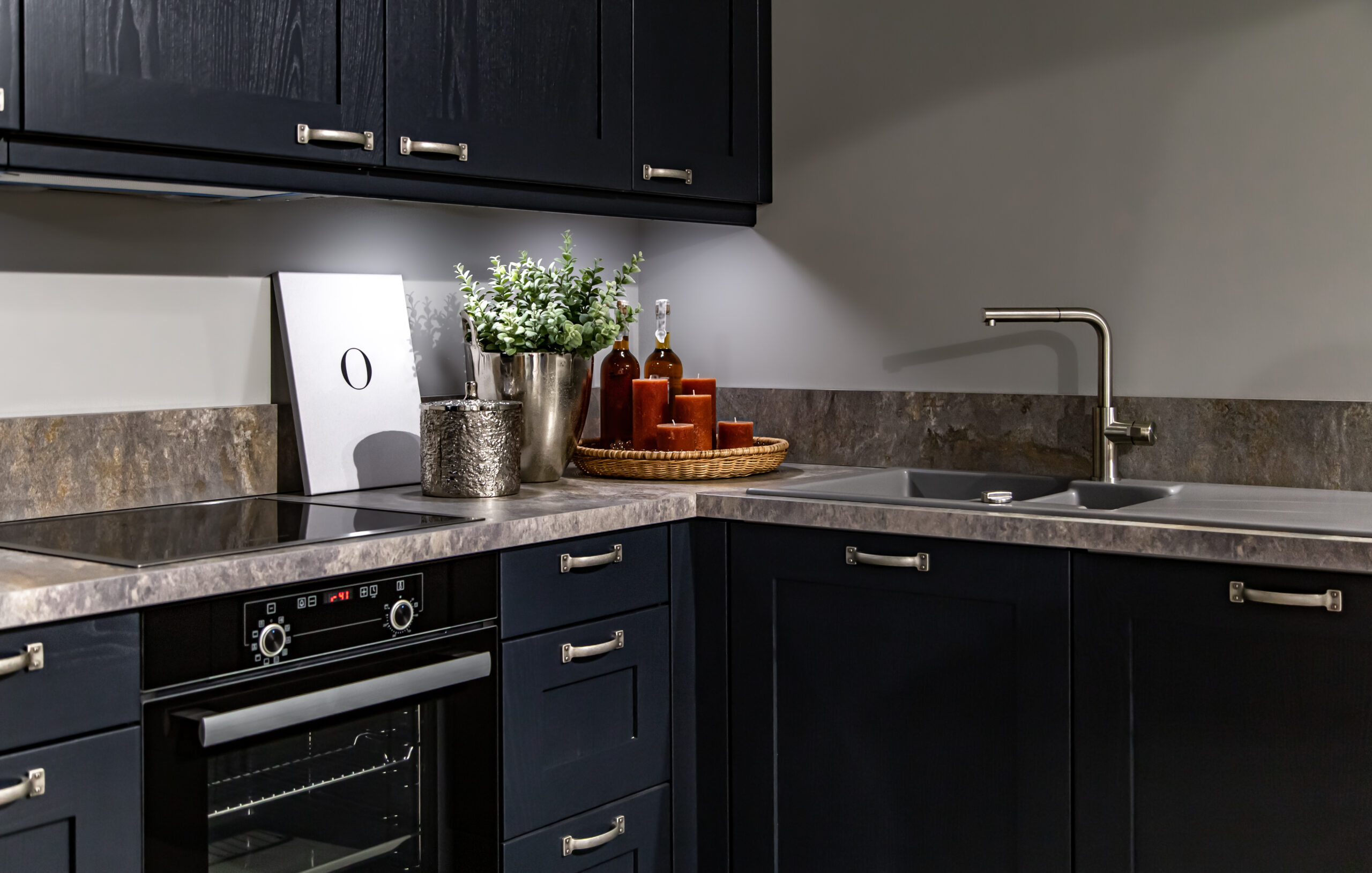 Modern kitchen corner with dark cabinets and marble countertop.