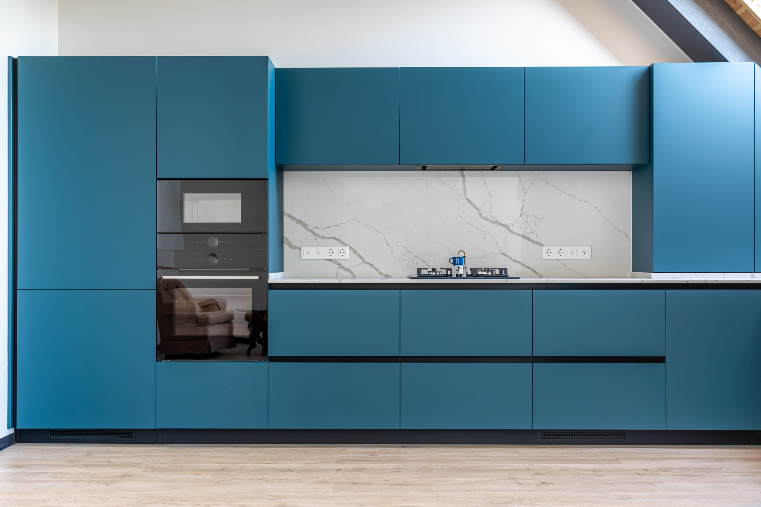 Modern kitchen with blue cabinets and marble backsplash.